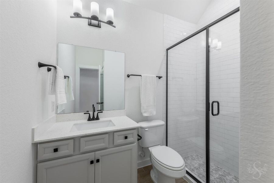 This beautifully appointed secondary bathroom offers a sleek vanity, modern black fixtures, and a spacious walk-in shower with a framed glass enclosure. Its clean, contemporary design provides comfort and style for guests or family members. This beautifully appointed secondary bathroom offers a sleek vanity, modern black fixtures, and a spacious walk-in shower with a framed glass enclosure. Its clean, contemporary design provides comfort and style for guests or family members.