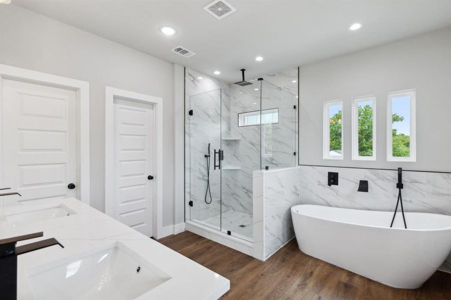 Bathroom featuring vanity, tile walls, hardwood / wood-style flooring, and separate shower and tub