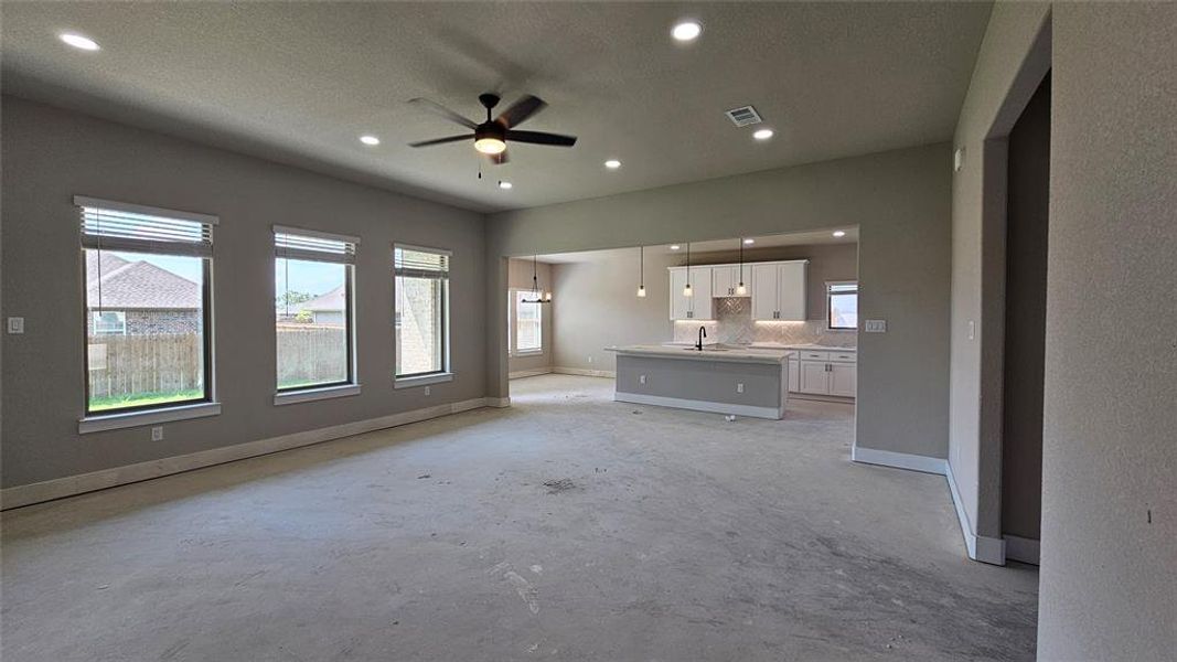 Unfurnished living room featuring sink, a textured ceiling, and ceiling fan