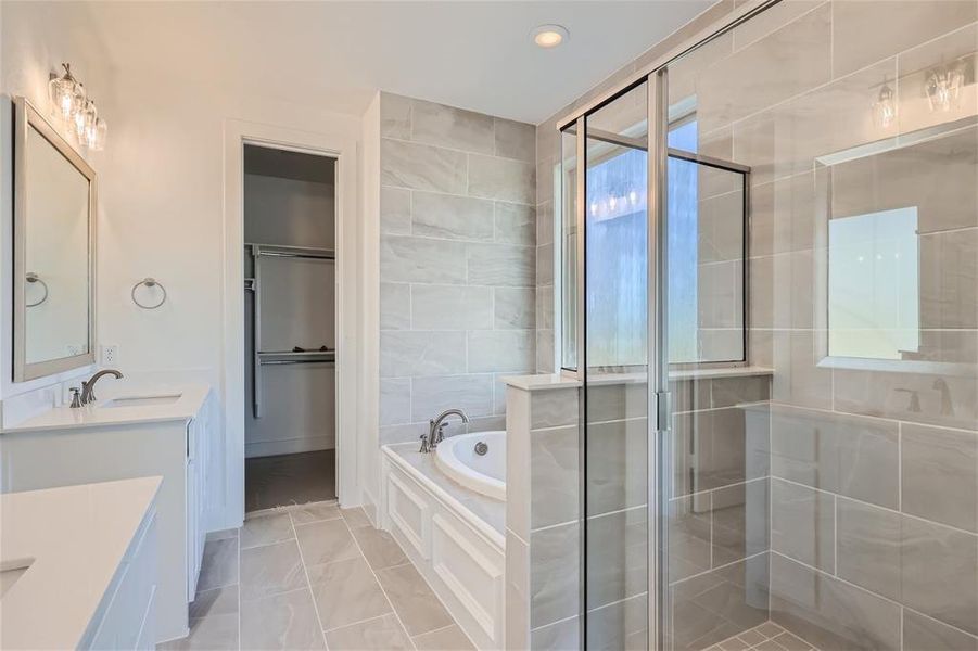 Bathroom featuring tile patterned flooring, independent shower and bath, vanity, and plenty of natural light