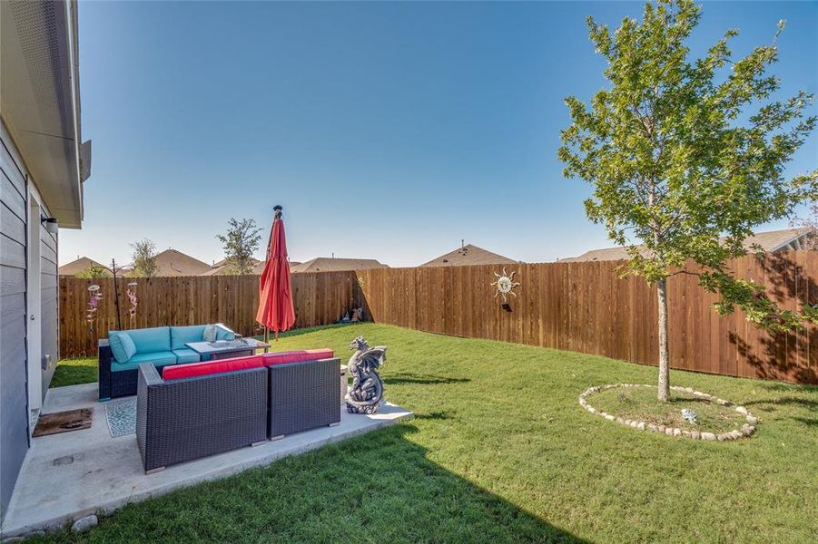 Back of house with an outdoor living space, a lawn, and a patio area