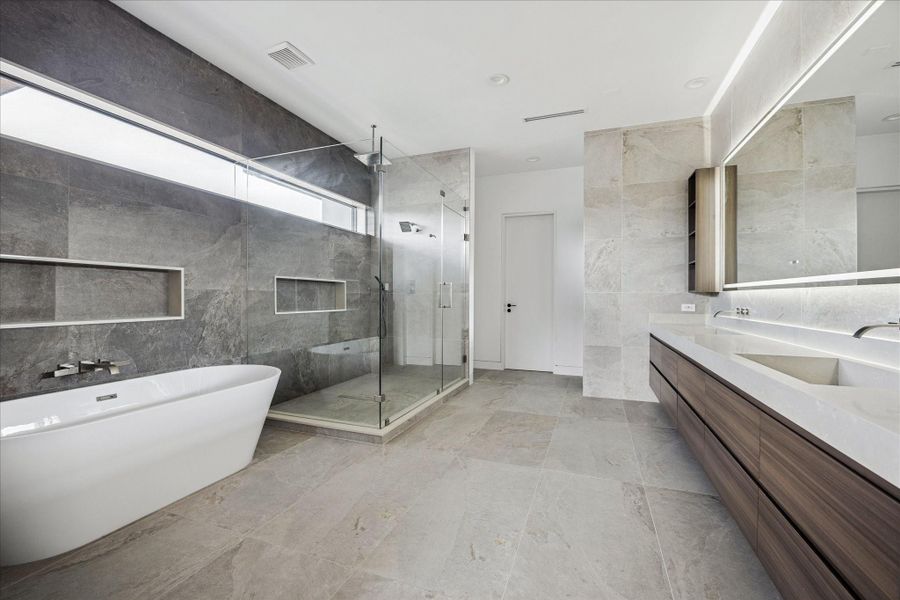 The luxurious primary bathroom offers a large shower, soaking tub and dual vanities.