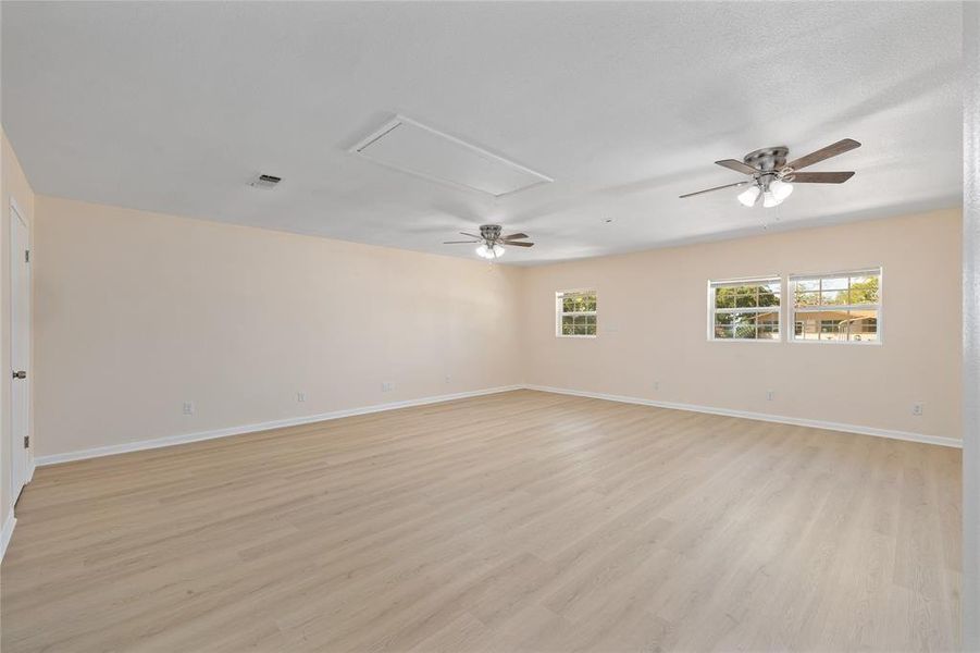 Empty room featuring a ceiling fan and light wood-type flooring