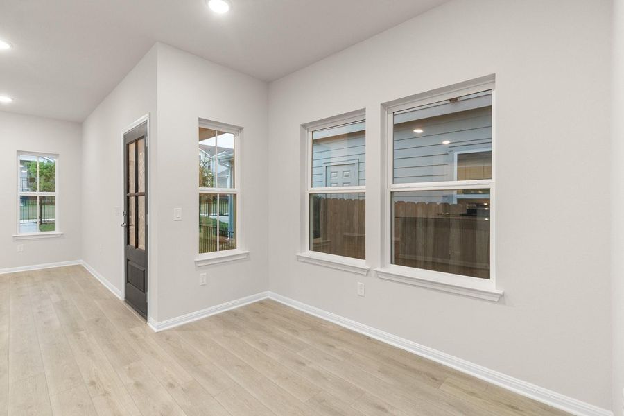 This living space features light-toned flooring, recessed lighting, and bright white walls