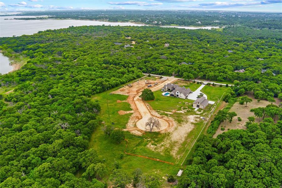 Expansive property featuring a large residence, separate garage structure, and swimming pool, surrounded by extensive mature tree coverage Expansive property featuring a large residence, separate garage structure, and swimming pool, surrounded by extensive mature tree coverage