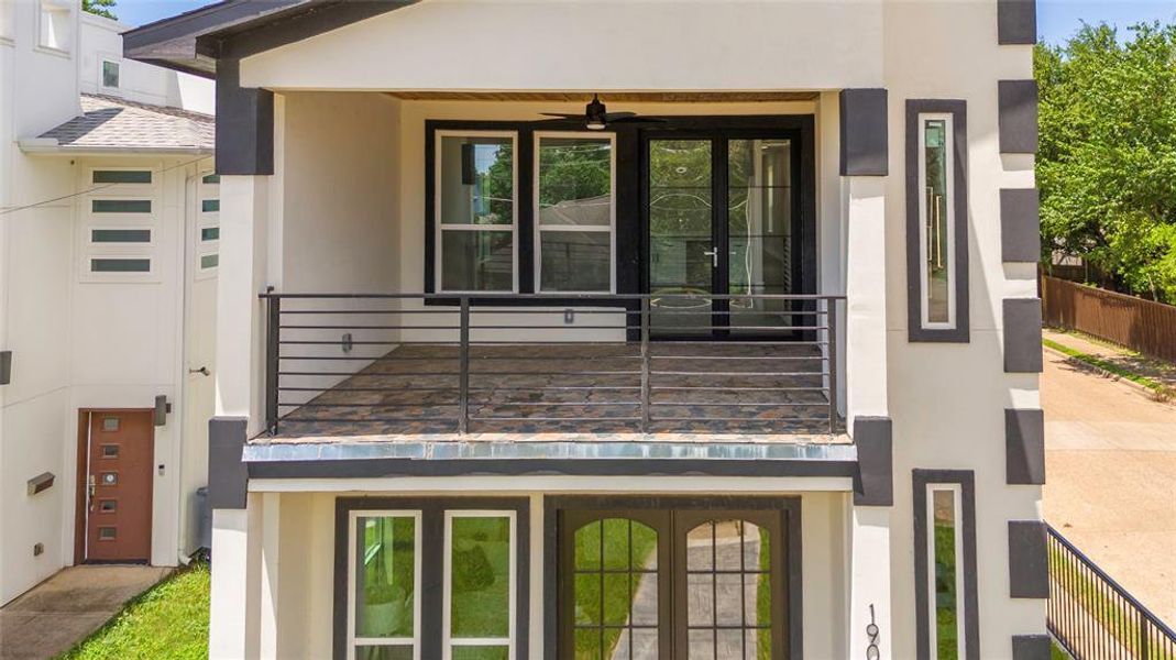 View of front of home featuring a balcony and ceiling fan