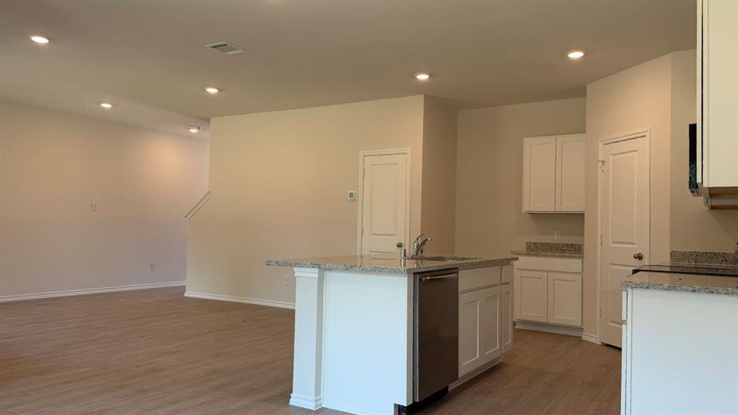 Kitchen island with a stainless steel dishwasher, an undermount sink, and granite countertops