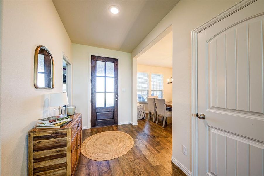 Foyer entrance featuring dark wood-type flooring and baseboards