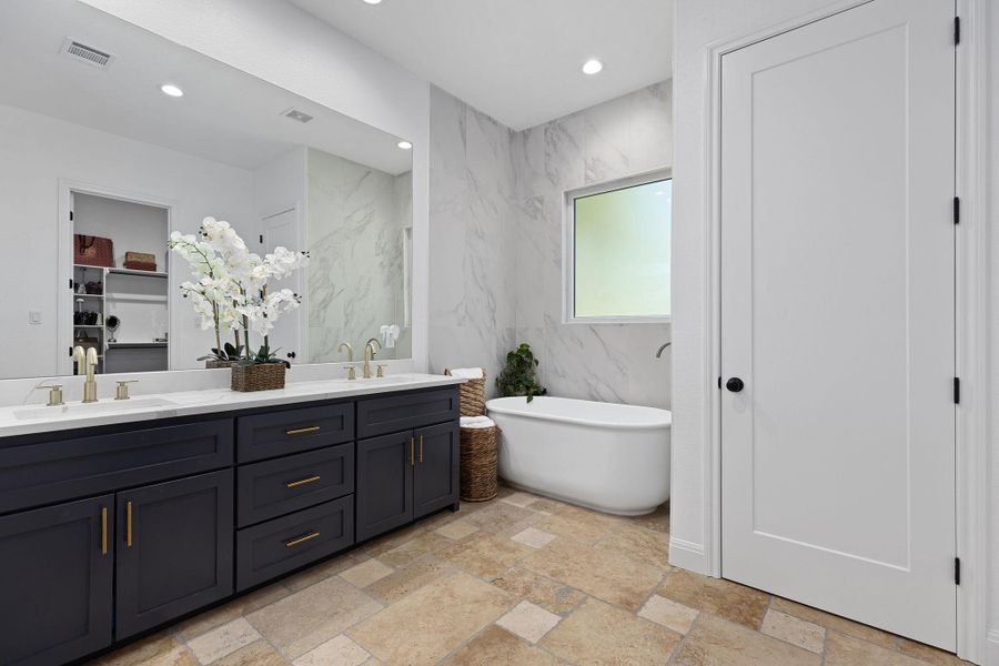 Full bathroom with a freestanding bath, double vanity, recessed lighting, and tile walls Full bathroom with a freestanding bath, double vanity, recessed lighting, and tile walls