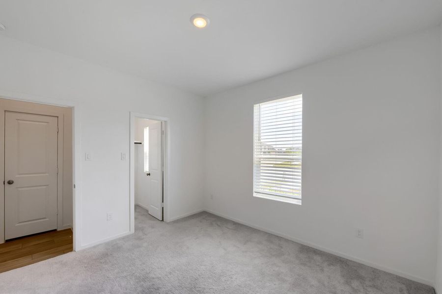Spacious walk-in closet with natural light, ideal for versatile use.