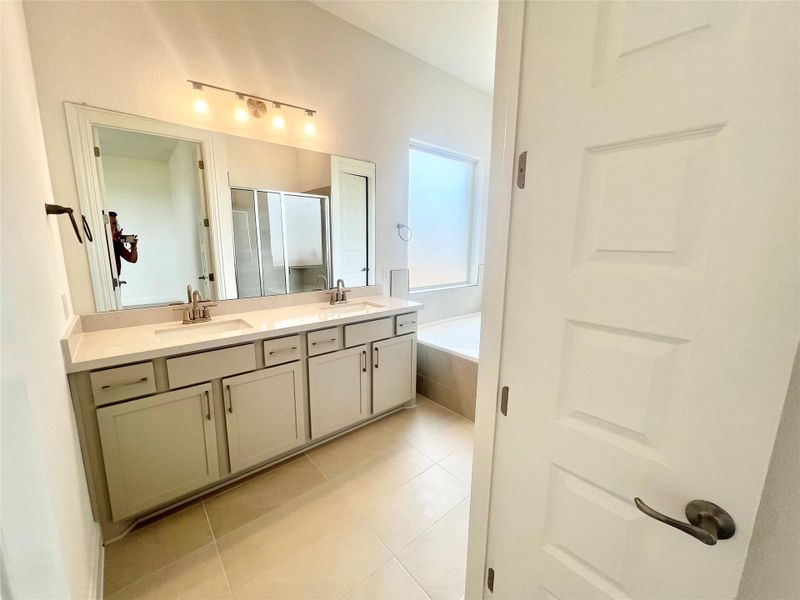 Bathroom with a stall shower, tile patterned floors, double vanity, and a bath Bathroom with a stall shower, tile patterned floors, double vanity, and a bath