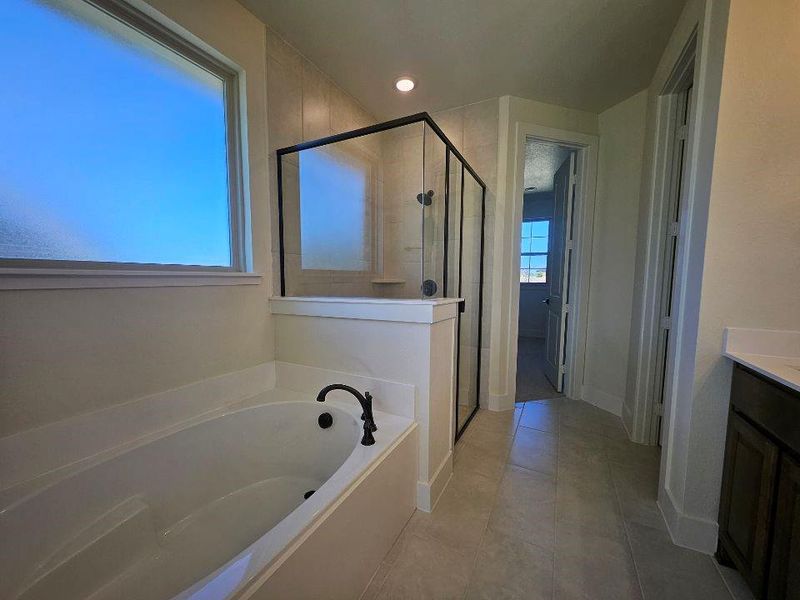 Bathroom with vanity, a garden tub, a shower stall, light tile patterned floors, and recessed lighting