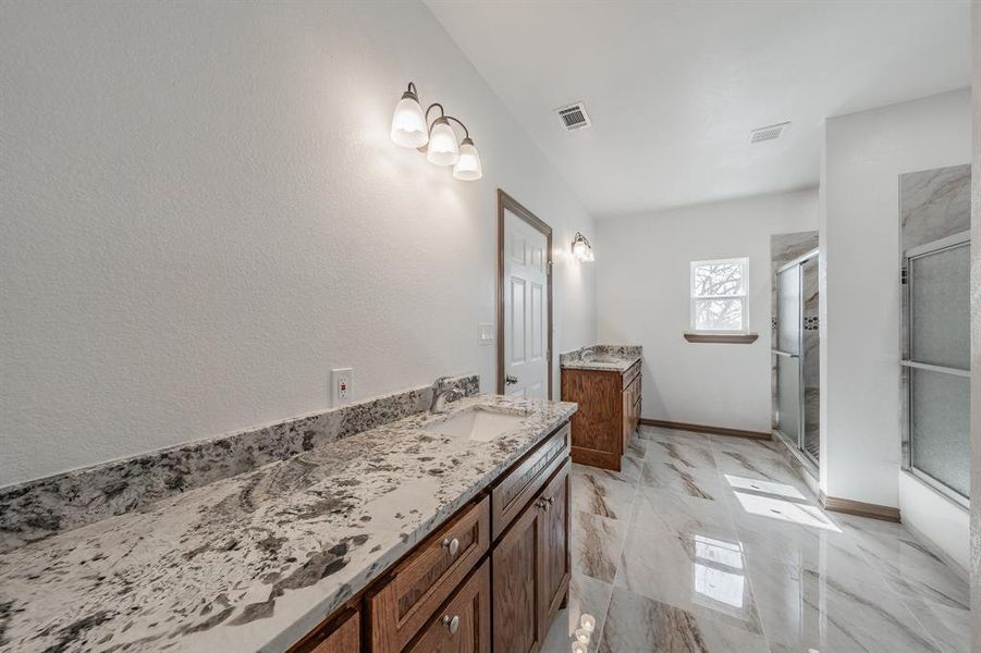 Full bath featuring visible vents, vanity, baseboards, marble finish floor, and a stall shower