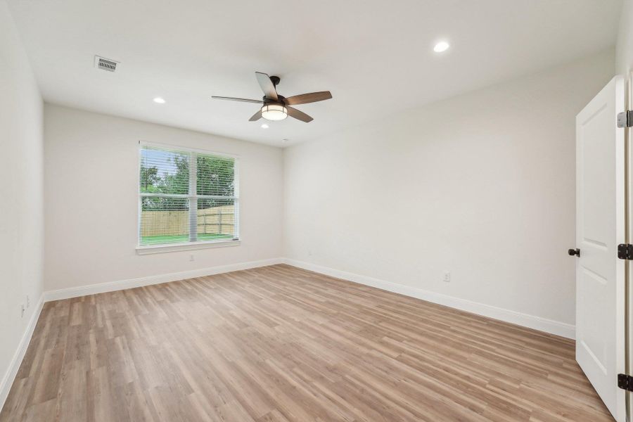 Primary bedroom with light wood-style flooring, visible vents, a ceiling fan, and baseboards Primary bedroom with light wood-style flooring, visible vents, a ceiling fan, and baseboards