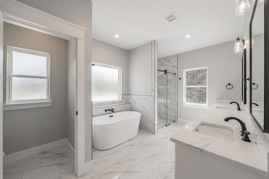 Bathroom featuring dual vanity, plus walk in shower, and tile patterned flooring