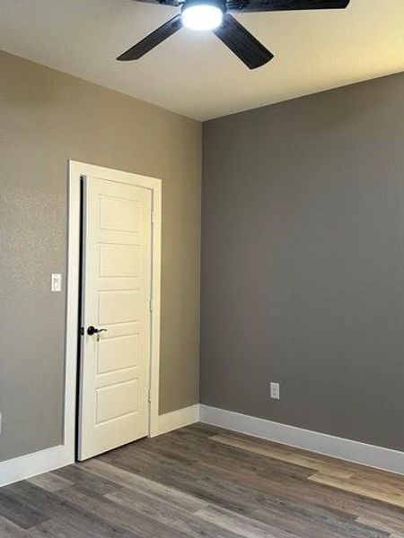 Empty room featuring ceiling fan and dark hardwood / wood-style floors