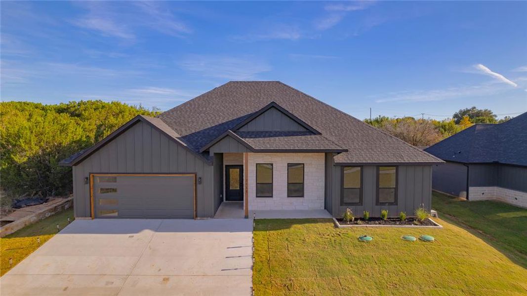 View of front facade featuring a garage and a front yard