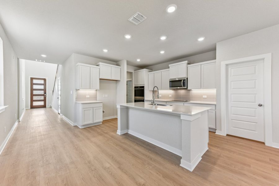 A kitchen with white cabinets.