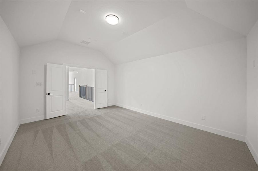 Bonus room featuring light colored carpet and vaulted ceiling