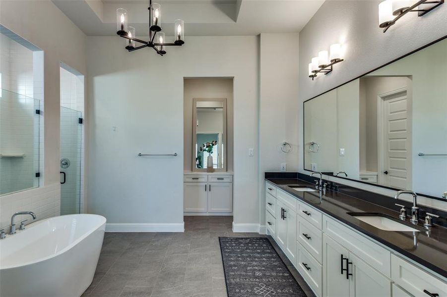 Bathroom featuring a freestanding tub, a stall shower, double vanity, and a chandelier Bathroom featuring a freestanding tub, a stall shower, double vanity, and a chandelier