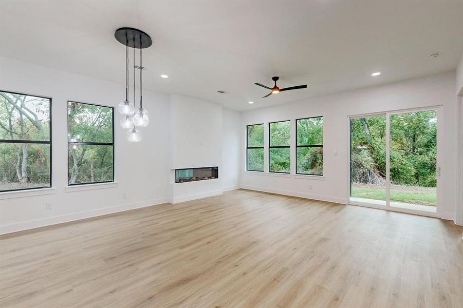 Unfurnished living room with ceiling fan and light hardwood / wood-style flooring