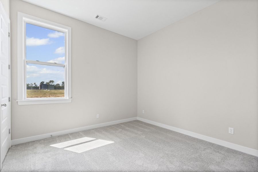 Carpeted spare room featuring baseboards