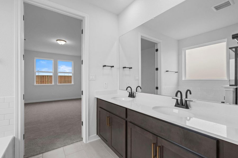 The en-suite bathroom offers a spa-like atmosphere with its elegant design, high end finishes, and tasteful lighting, creating a retreat within your own home.