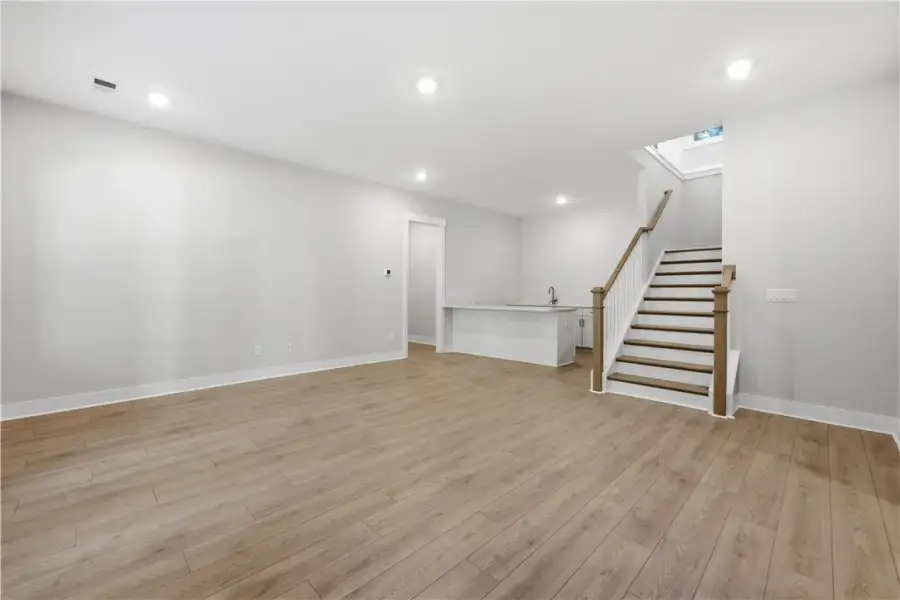 Smooth wood floors anchor this open lower level la