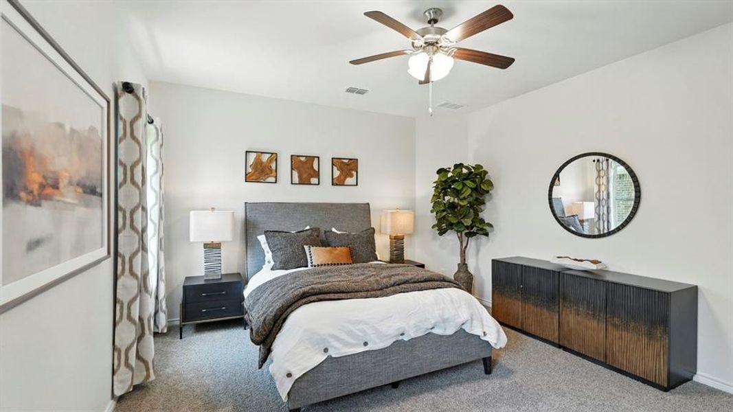 Carpeted bedroom featuring ceiling fan and baseboards
