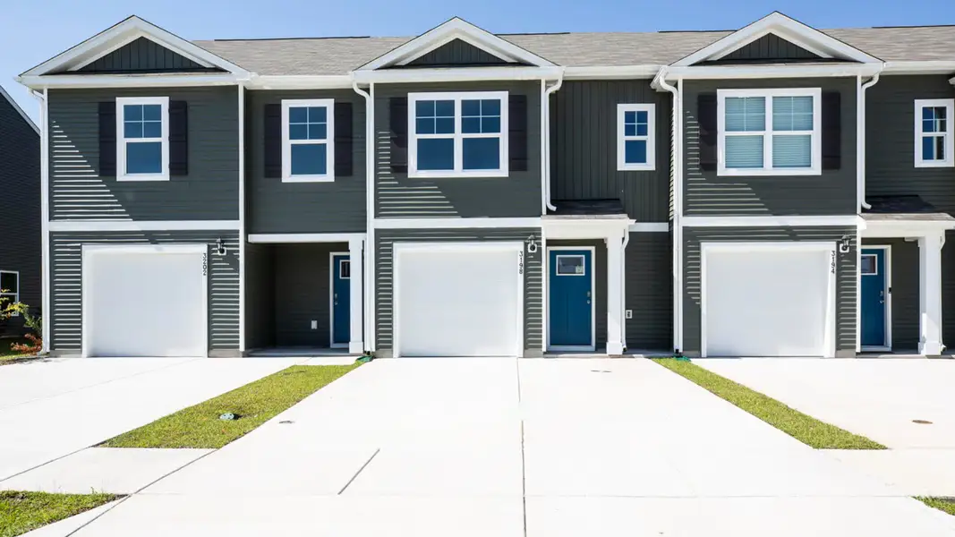 Front exterior of a new home in Waterside Townhomes, Surf City, NC, highlighting curb appeal (Image 1).