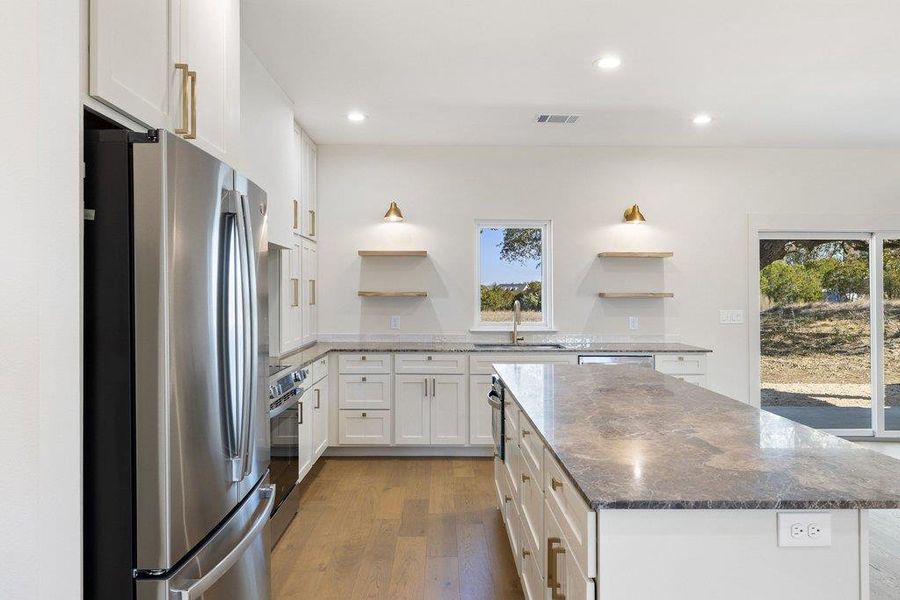 Kitchen featuring open shelves, dark stone countertops, stainless steel appliances, white cabinetry, and recessed lighting