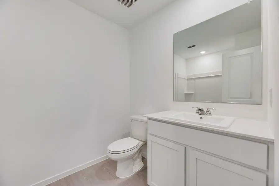 Half bathroom with vanity and light wood-style flooring