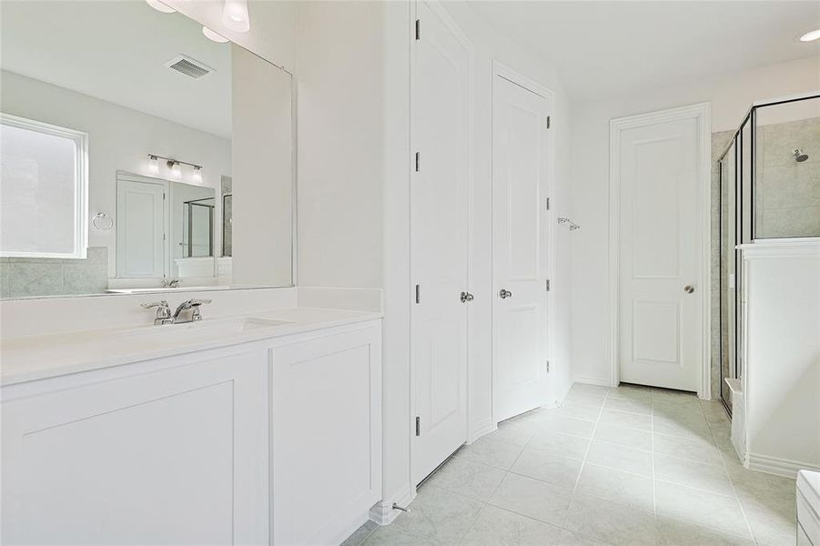 Bathroom with vanity, tile patterned floors, and an enclosed shower