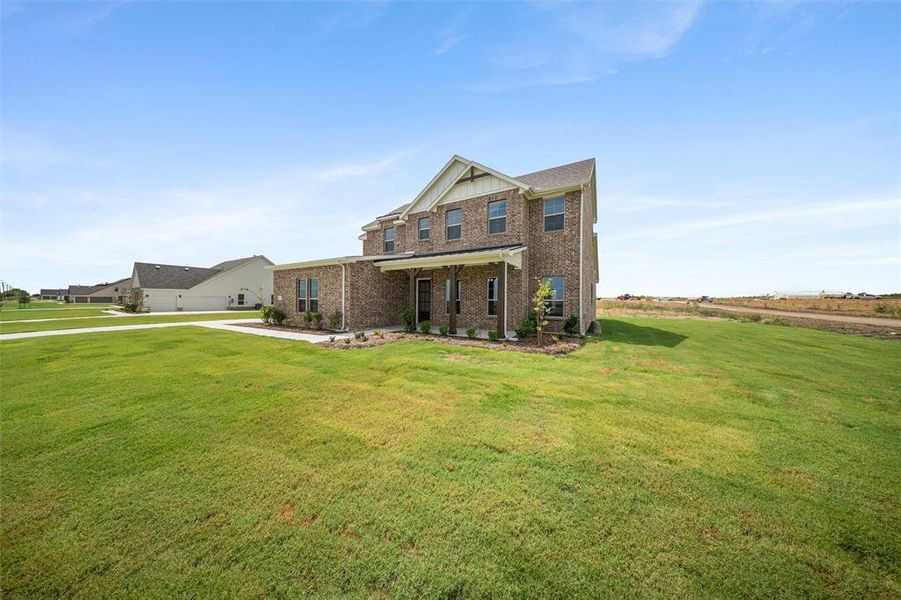View of front facade featuring brick siding, a front lawn, and covered porch View of front facade featuring brick siding, a front lawn, and covered porch