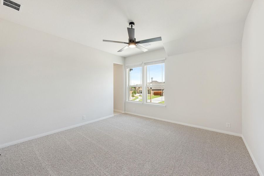 Empty bedroom with carpet flooring, ceiling fan, and a window overlooking the neighborhood Empty bedroom with carpet flooring, ceiling fan, and a window overlooking the neighborhood