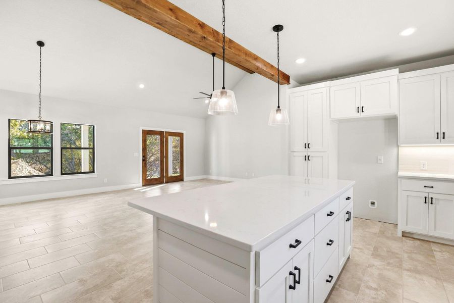 A well-lit open-concept kitchen and living area featuring a large center island and abundant natural light. A well-lit open-concept kitchen and living area featuring a large center island and abundant natural light.
