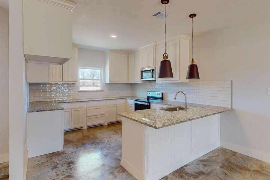 Kitchen with sink, hanging light fixtures, electric range, kitchen peninsula, and decorative backsplash