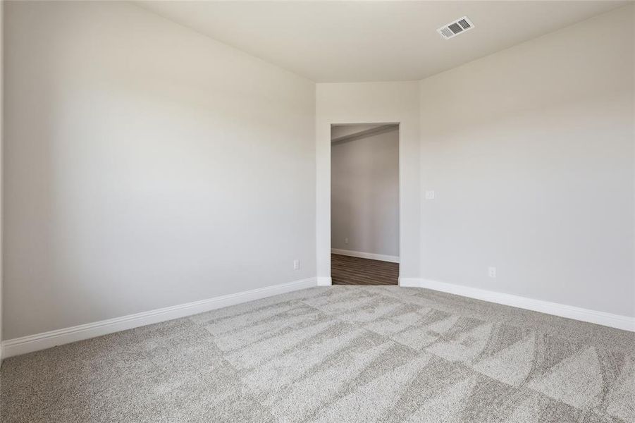 Empty room featuring light colored carpet and baseboards Empty room featuring light colored carpet and baseboards