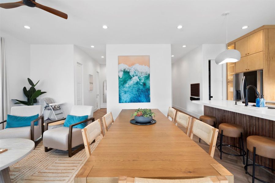 This modern coastal kitchen and dining area showcases a warm, natural palette with a long wooden dining table as its centerpiece. Paired with modern armchairs in light upholstery and sleek dark frames, the space balances comfort and minimalism. Clean lines, organic textures, and soft tones reflect a relaxed yet sophisticated coastal aesthetic. This modern coastal kitchen and dining area showcases a warm, natural palette with a long wooden dining table as its centerpiece. Paired with modern armchairs in light upholstery and sleek dark frames, the space balances comfort and minimalism. Clean lines, organic textures, and soft tones reflect a relaxed yet sophisticated coastal aesthetic.