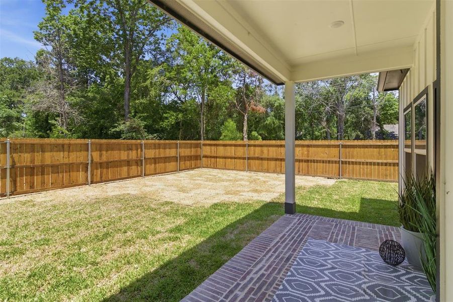 Covered outdoor patio featuring brick-patterned flooring