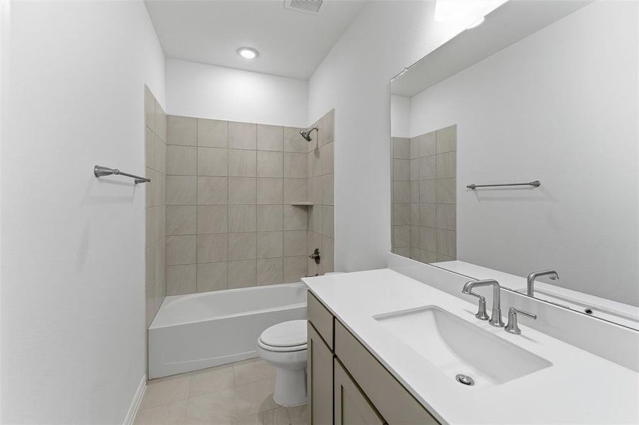Contemporary bathroom featuring a combined tub and shower with tile surround and built-in niche
