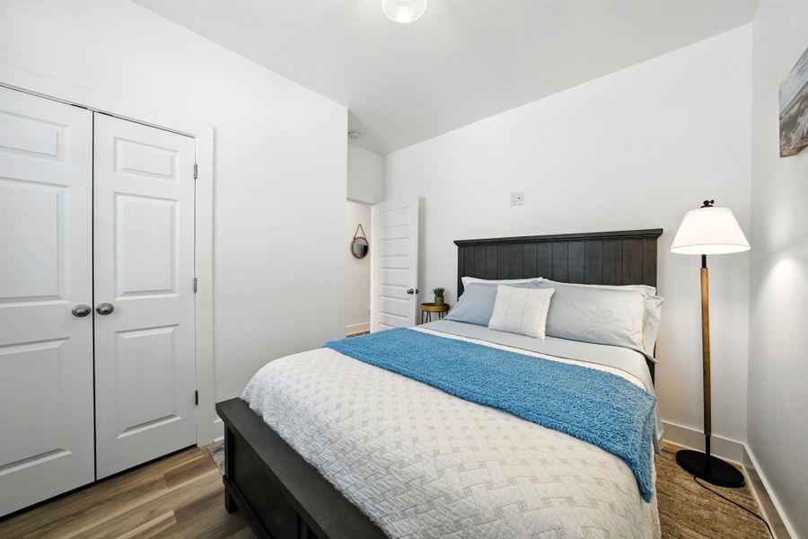 Bedroom featuring vinyl plank floors, high ceiling and generous closet Bedroom featuring vinyl plank floors, high ceiling and generous closet