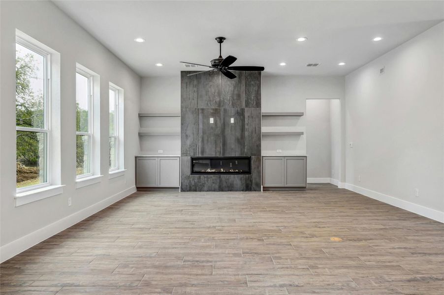 Unfurnished living room with a healthy amount of sunlight, a fireplace, and light wood finished floors