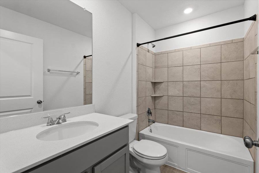 A well-appointed bathroom features a single vanity, a standard toilet, and a tiled shower-over-tub combination. A well-appointed bathroom features a single vanity, a standard toilet, and a tiled shower-over-tub combination.