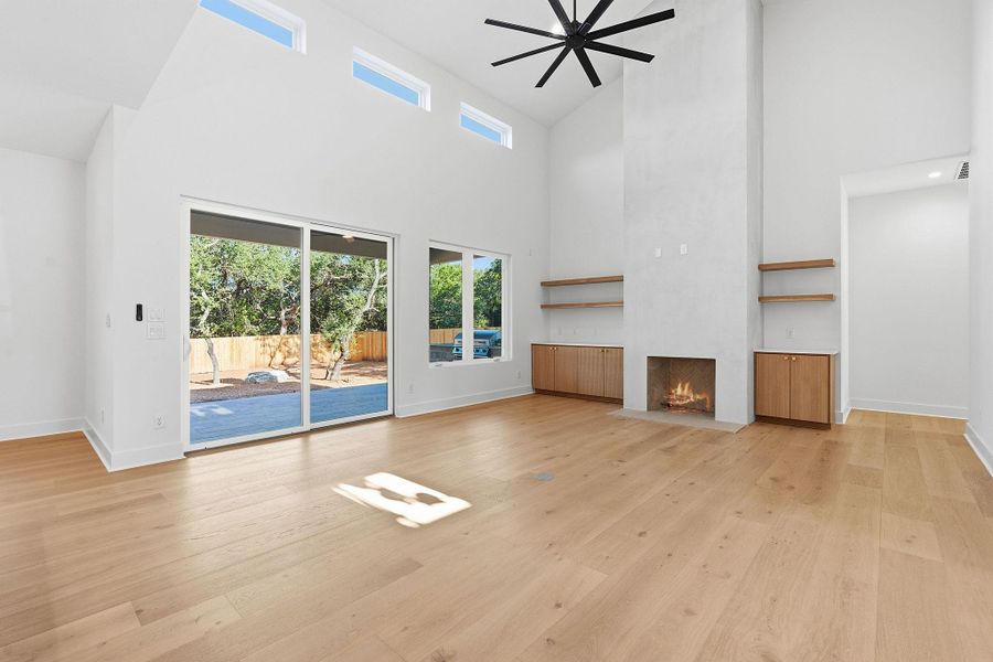 Hardwood floors and a towering fireplace define this airy living space with high clerestory windows.