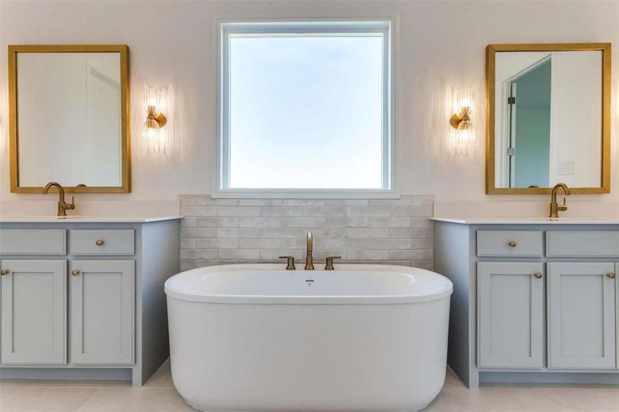 Bathroom featuring two vanities, a soaking tub, and plenty of natural light Bathroom featuring two vanities, a soaking tub, and plenty of natural light