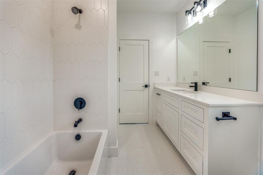 Bathroom featuring tile patterned floors, vanity, and tiled shower / bath combo