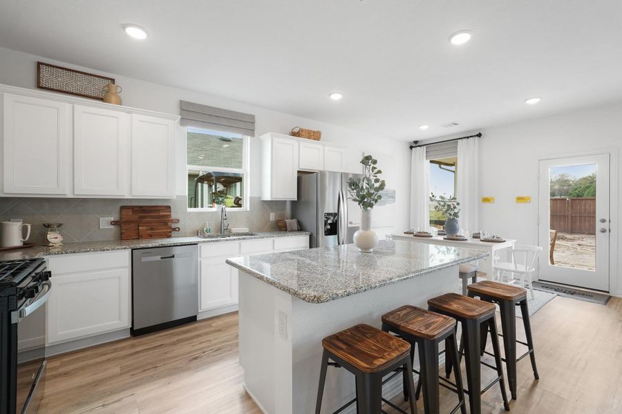 Every detail has been thoughtfully designed, from the state-of-the-art appliances that make meal prep a breeze, to the charming backsplash that adds a touch of personality.