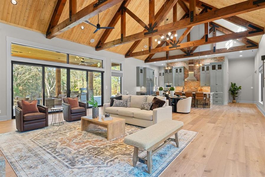 Living area with a chandelier, high vaulted ceiling, light wood-style floors, recessed lighting, and beamed ceiling
