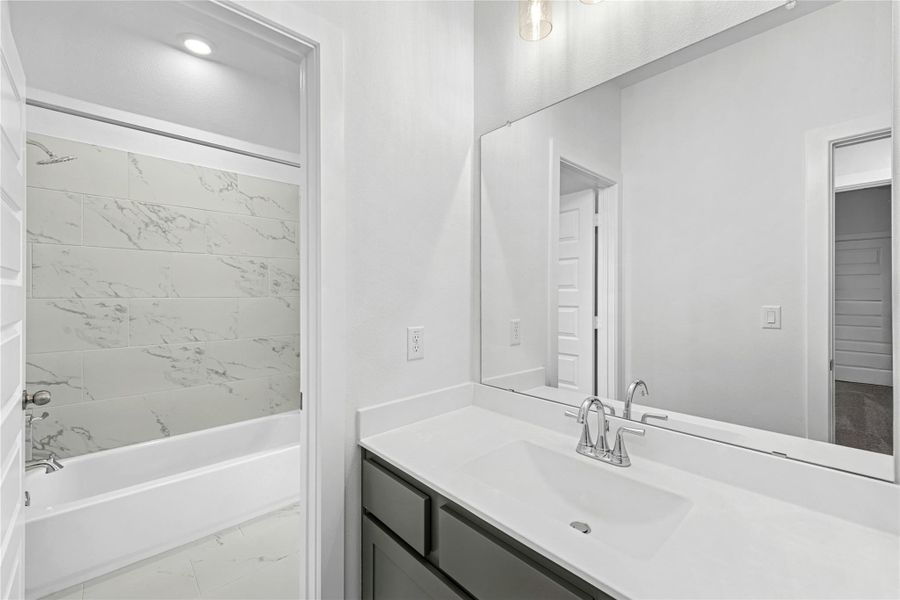 Bathroom featuring vanity and washtub / shower combination